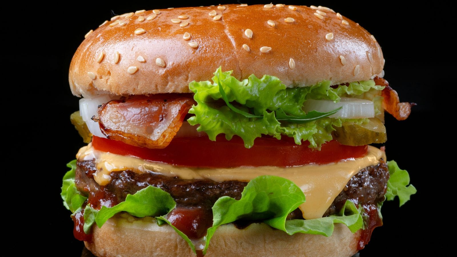 Klasický cheeseburger na černém pozadí